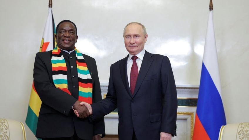 Russia's President Vladimir Putin shakes hands with Zimbabwe's President Emmerson Mnangagwa.