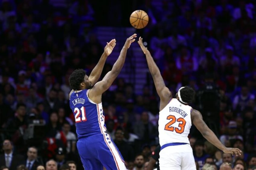 Joel Embiid of the Philadelphia 76ers shoots over New York's Mitchell Robinson in the 76er