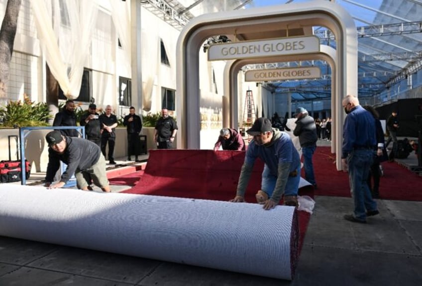 Workers unroll the red carpet ahead of the Golden Globes