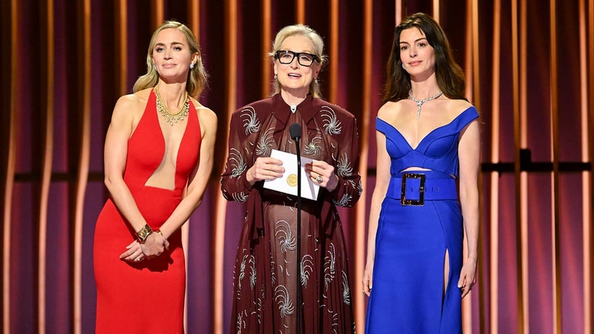 Emily Blunt, Meryl Streep, Anne Hathaway at microphone on stage together
