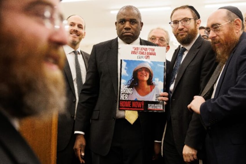 Britain's Foreign Secretary David Lammy holding a poster showing hostage Emily Damari