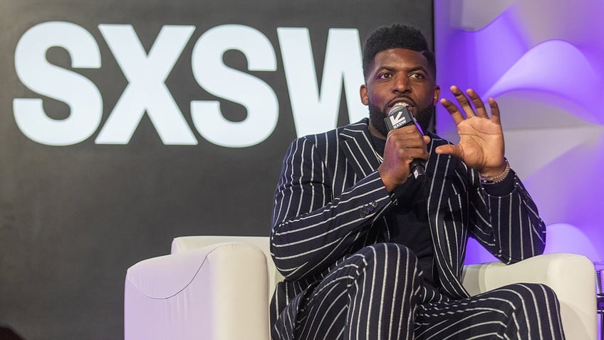 Emmanuel Acho speaks onstage