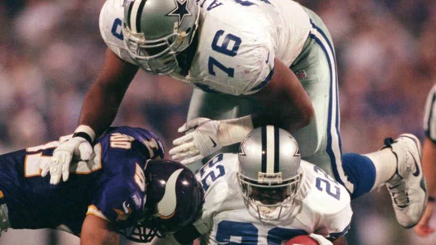 Larry Allen jumps over Emmitt Smith