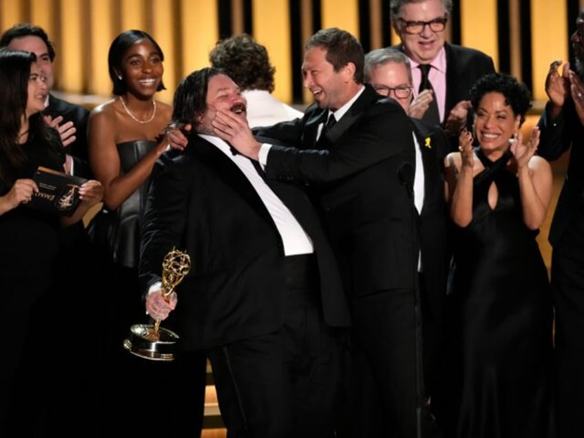 emmys Matty Matheson, center, and Ebon Moss-Bachrach kiss as "The Bear" wins the award for outstanding comedy series during the 75th Primetime Emmy Awards on Monday, Jan. 15, 2024, at the Peacock Theater in Los Angeles. (AP Photo/Chris Pizzello)