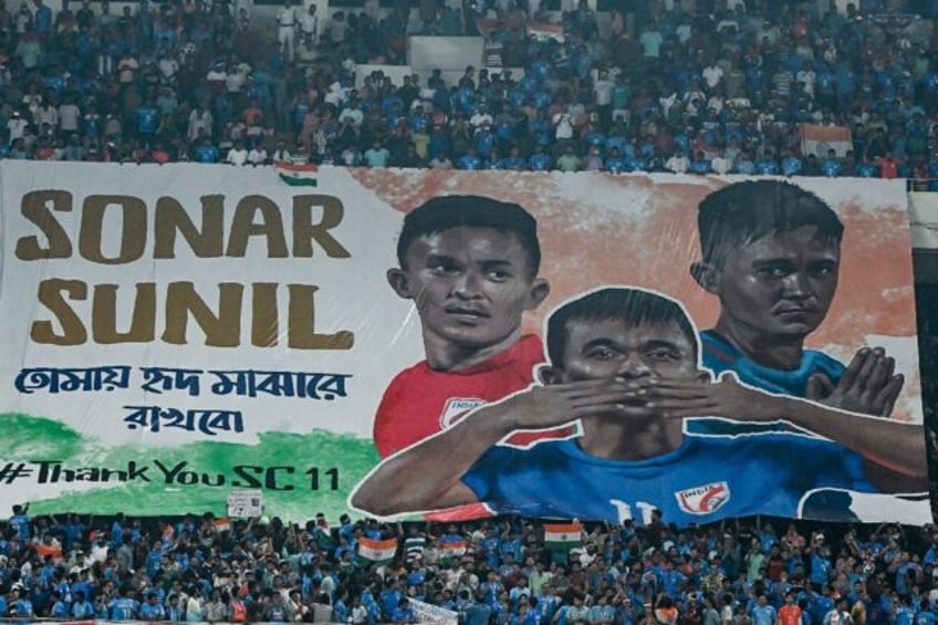 Fans in Kolkata hold a banner displaying photos of India's Sunil Chhetri