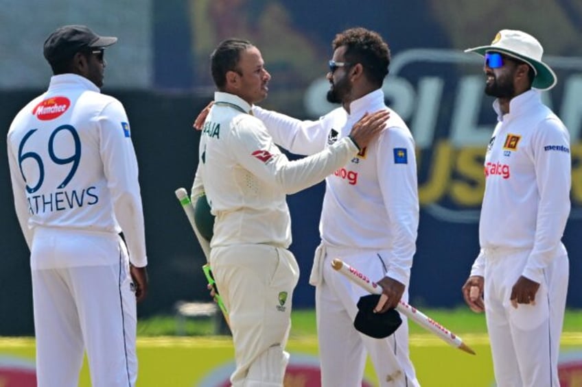 Australia's Usman Khawaja (second left) congratulates the retiring Dimuth Karunaratne (sec