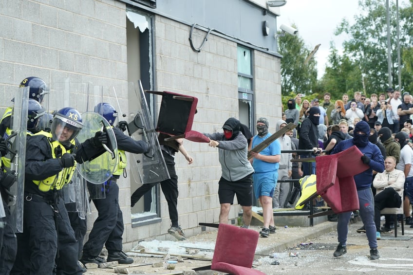 A chair is thrown at police officers as trouble flares during an anti-immigration protest outside the Holiday Inn Express in Rotherham, South Yorkshire. Picture date: Sunday August 4, 2024. (Photo by Danny Lawson/PA Images via Getty Images)