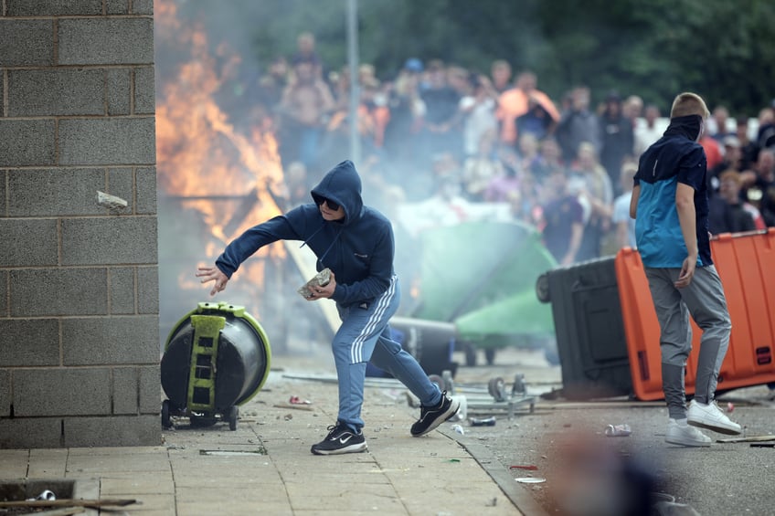 ROTHERHAM, ENGLAND - AUGUST 4: Riot police clash with anti-migration protesters outside of the Holiday Inn Express in Manvers, which is being used as an asylum hotel, on August 4, 2024 in Rotherham, United Kingdom. Yesterday saw widespread violence as Far-right agitators in Liverpool and Manchester rioted and looted shops. Police were attacked and injured and dozens of arrests were made. (Photo by Christopher Furlong/Getty Images)