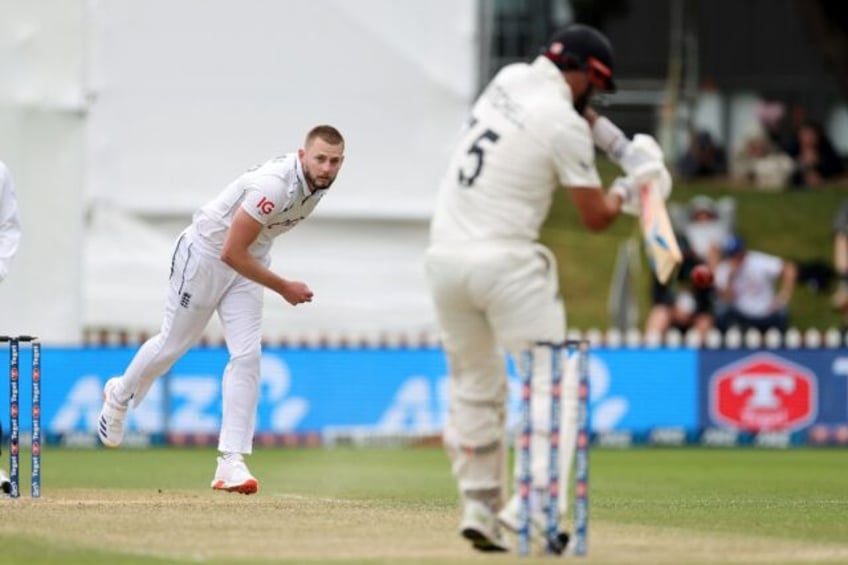 England's Gus Atkinson (L) bowls to New Zealand's Daryl Mitchell