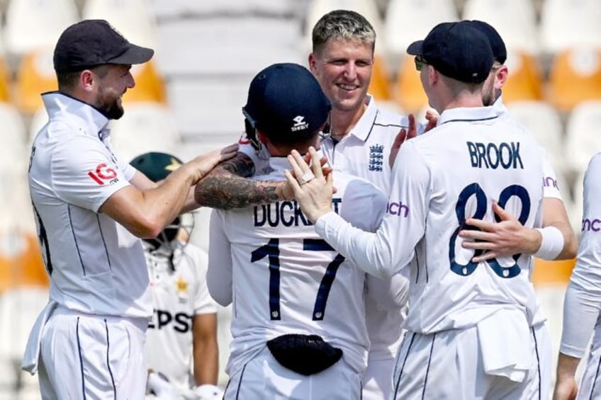 England's Brydon Carse (3R) celebrates his first Test wicket