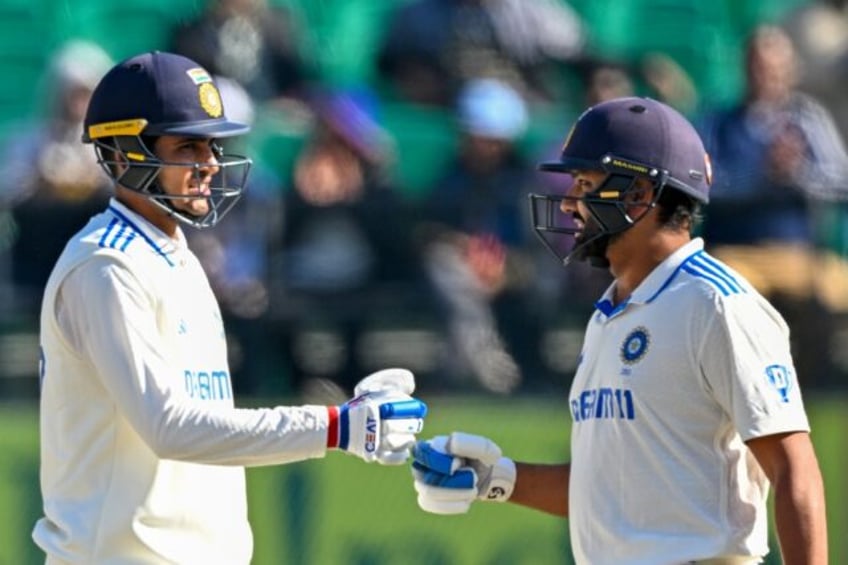 India's captain Rohit Sharma (R) fist bumps Shubman Gill during the second day of the fift