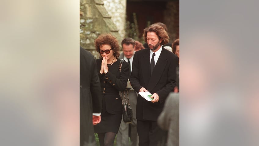 Eric Clapton looking somber in a suit