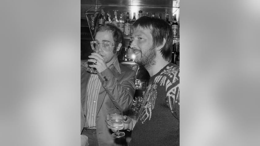 Elton John and Eric Clapton enjoying a drink together