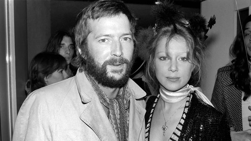 A close-up of Eric Clapton with his wife Pattie Boyd looking serious