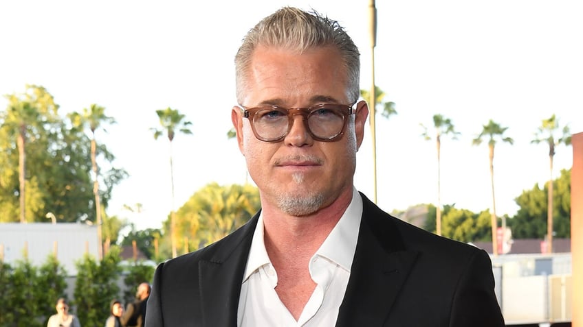 Eric Dane wears glasses with a black blazer and white shirt.