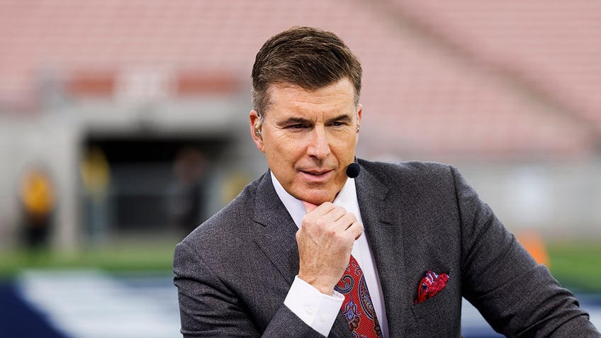 Rece Davis looks on field with microphone