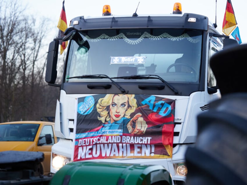 08 January 2024, Berlin: An AfD banner can be seen on a truck on the sidelines of a farmers' protest on the Straße des 17. In response to the federal government's austerity plans, the farmers' association has called for a week of action with rallies and rallies starting on January …