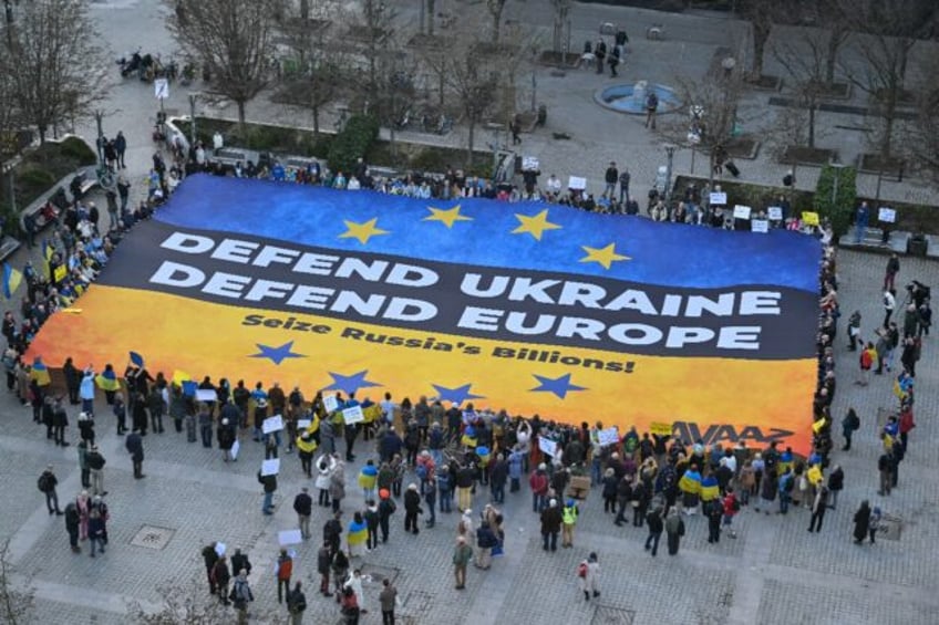 Demonstrators display a giant banner in the colours of the Ukrainian flag in Brussels on t