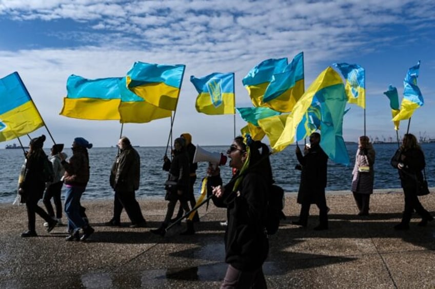 Ukrainians living in Greece wave Ukrainian flags during a demonstration in Thessaloniki on