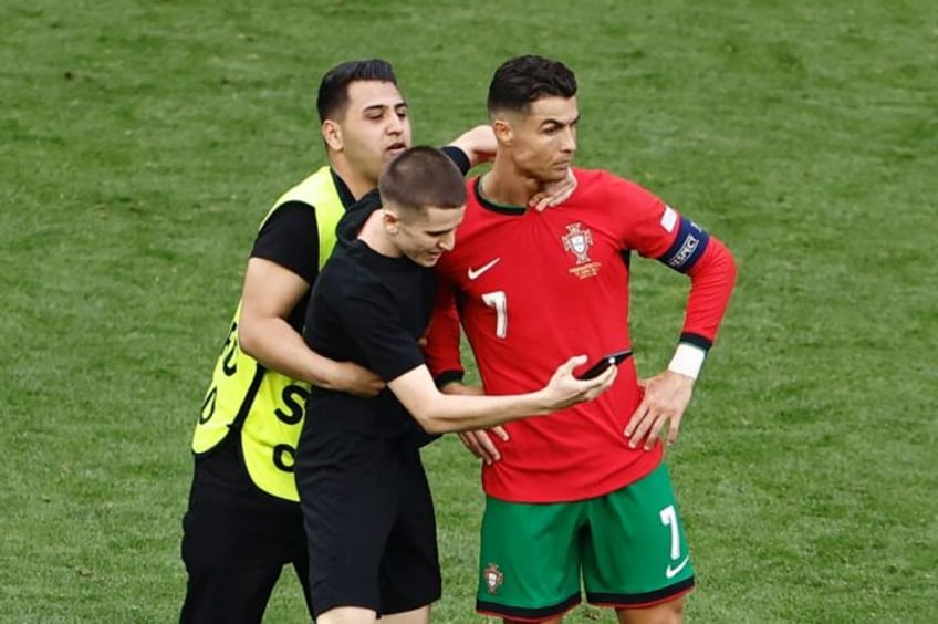 Several pitch invaders tried to take selfies with Cristiano Ronaldo during the win over Tu
