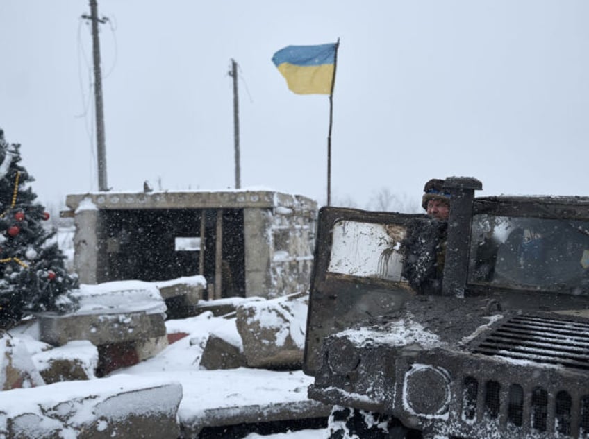 BAKHMUT REGION, UKRAINE - DECEMBER 25: Ukrainian soldiers passing by in a HMMWV stop to take a photo of a Christmas tree at a destroyed checkpoint on a road which is constantly under fire from FPV drones on December 25, 2023 in Bakhmut region, Ukraine. This Christmas tree is known …