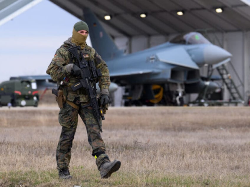 05 December 2023, Romania, Constanta: A Bundeswehr soldier walks past a German Eurofighter at the Mihail Kogalniceanu airfield near Constanta (Romania). The German Air Force is currently supporting NATO member Romania with Eurofighter combat aircraft and a defense system against small unmanned aerial vehicles in the NATO program "Enhanced Air …