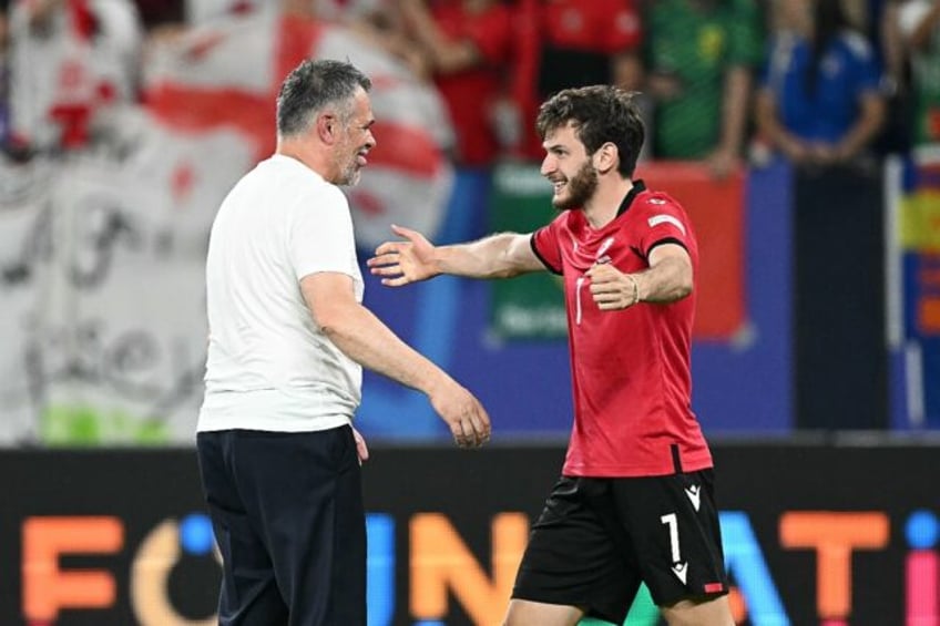 Willy Sagnol (L) and Khvicha Kvaratskhelia celebrate after Georgia beat Portugal