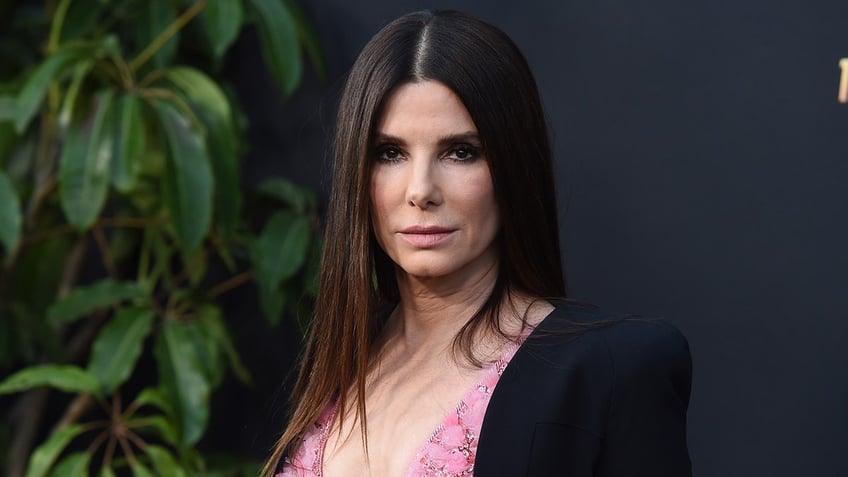 Sandra Bullock in a pink dress and black jacket at "The Lost City" premiere