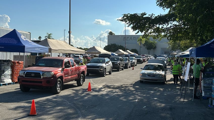 Vehicles make their way through Place of Hope's food distribution line in the parking lot of the Boynton Beach Mall in Florida.