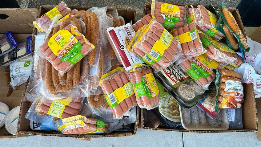 Hot dogs and sausages sit on a table at Place of Hope's drive-thru food distribution.