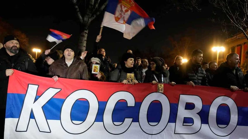 Serbians holding a Kosovo flag