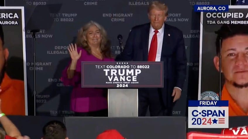 Cindy Romero stands on stage with former President Donald Trump