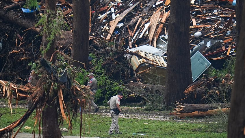 Emergency workers search through rubble to find missing people after flash flood.