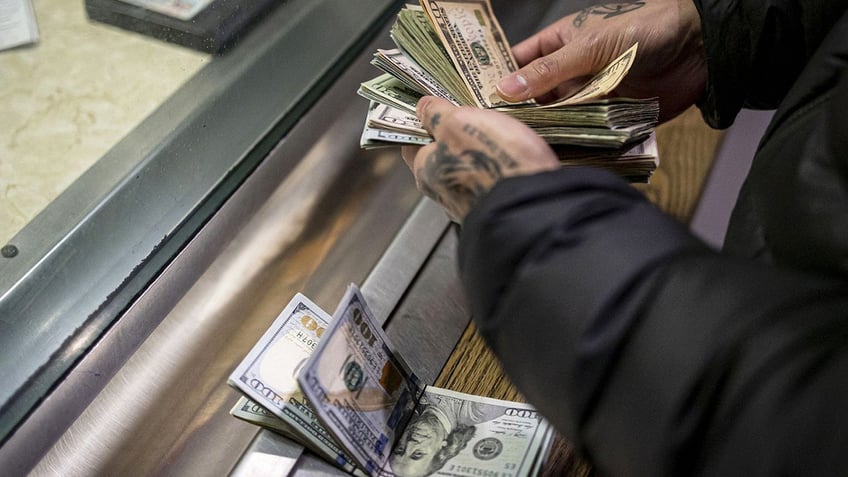 A man pays cash bail in the bond office to secure his brother's release on Dec. 21, 2022, at Division 5 of the Cook County Jail.