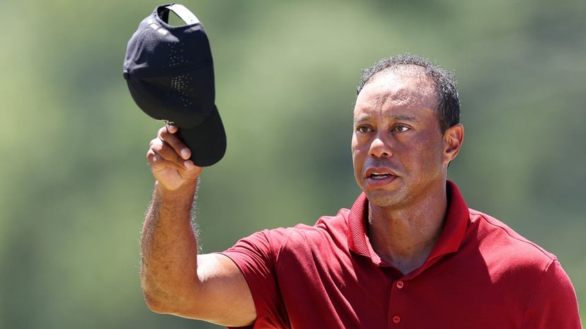 Tiger Woods waves his hat