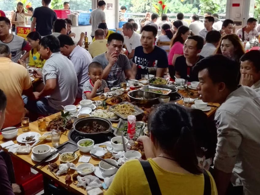 People eat dog meat at a restaurant in Yulin, in China's southern Guangxi region on June 21, 2017. China's most notorious dog meat festival opened in Yulin on June 21, 2017, with butchers hacking slabs of canines and cooks frying the flesh following rumours that authorities would impose a ban this year. / AFP PHOTO / STR / CHINA OUT (Photo credit should read STR/AFP via Getty Images)