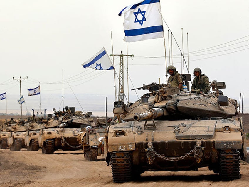 Israeli Merkava tanks drive near the border between Israel and the Gaza Strip as they return from the Hamas-controlled Palestinian coastal enclave on August 5, 2014, after Israel announced that all of its troops had withdrawn from the Gaza Strip. Israel completed the withdrawal of all troops from Gaza as …