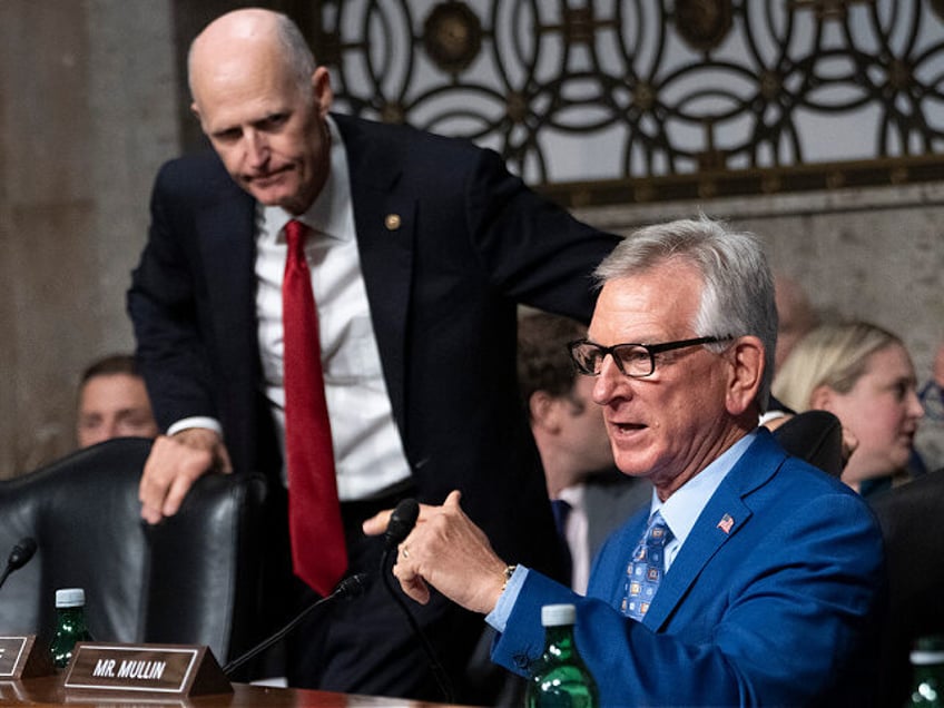 Sen. Rick Scott, R-Fla., left, listens as Sen. Tommy Tuberville, R-Ala., asks a question o