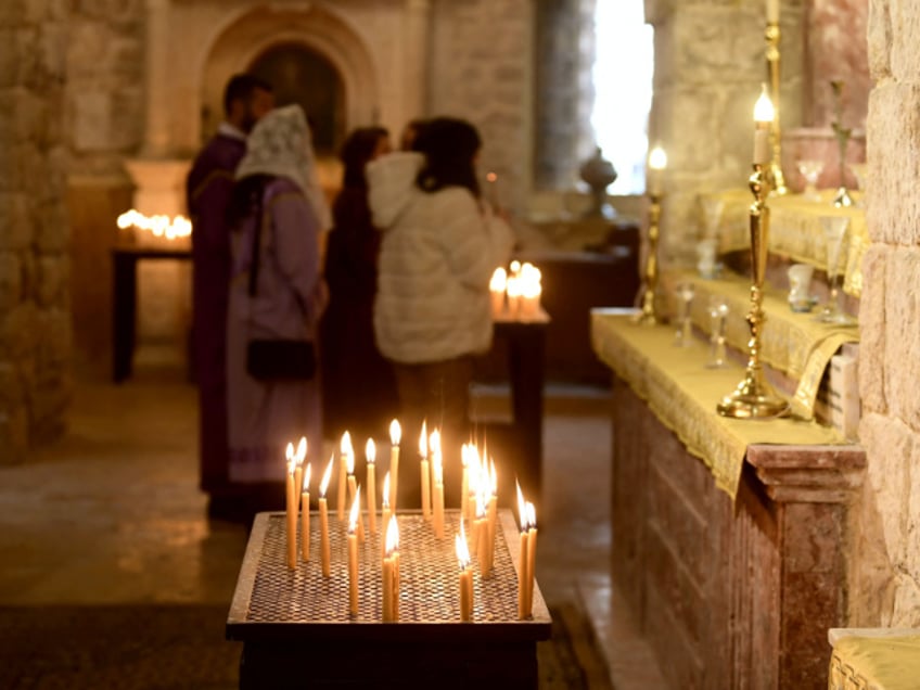 Worshippers light candles at the Armenian Orthodox Church in the Old City of Aleppo in northern Syria on January 6, 2022 as Orthodox Christians celebrate Christmas. (Photo by AFP) (Photo by -/AFP via Getty Images)