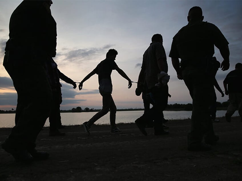 WESLACO, TX - APRIL 13: Undocumented immigrants are led after being caught and handcuffed