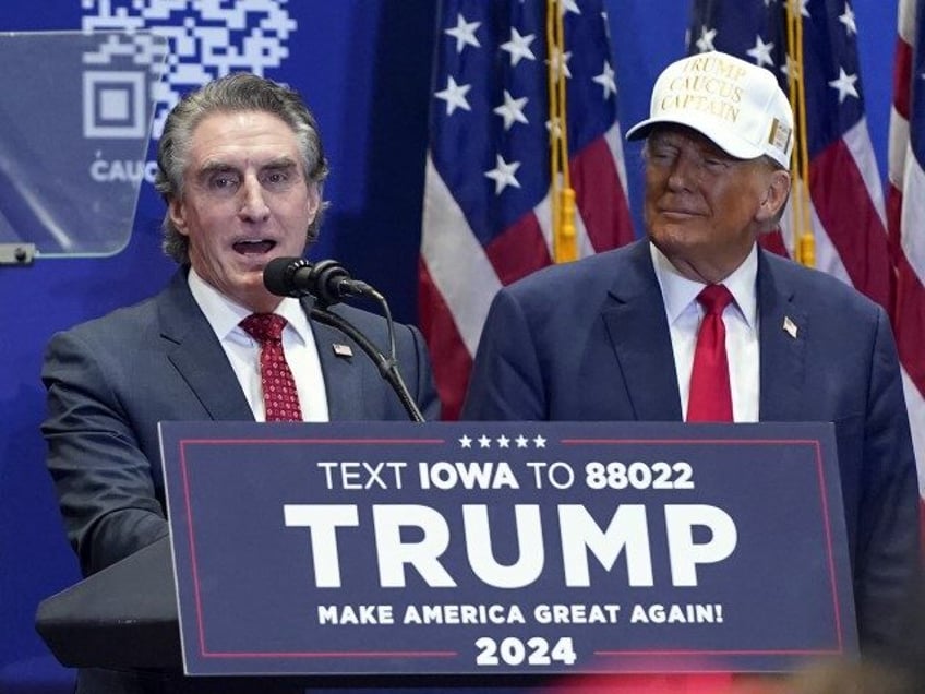 Republican presidential candidate former President Donald Trump listens as North Dakota Gov. Doug Burgum speaks at a rally at Simpson College in Indianola, Iowa, Sunday, Jan. 14, 2024. (Andrew Harnik/AP)