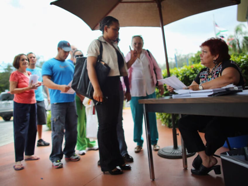 People stand in line to deliver their voter registration forms to a Miami-Dade Elections D