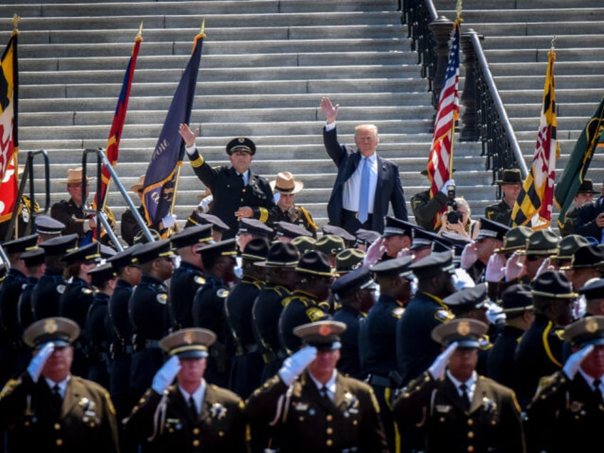 President Trump, right, waves to the crowd as he arrives with Chuck Canterbury, left, Pres