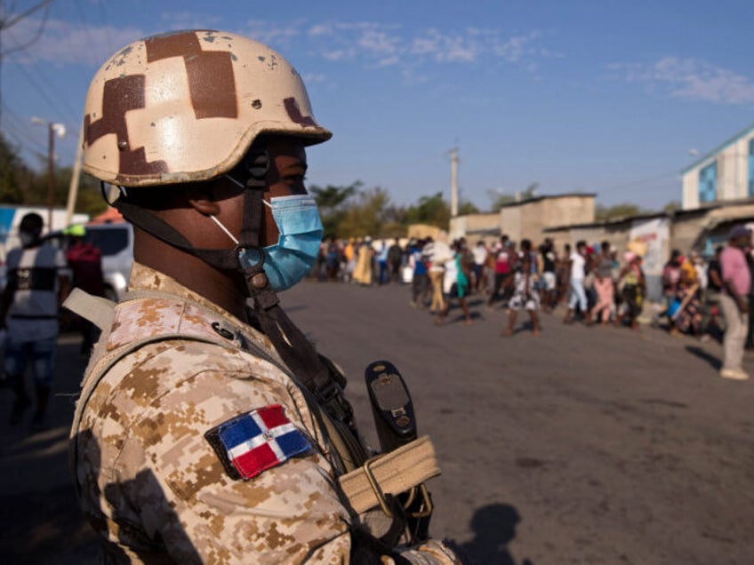 A Dominican military agent controls the passage of Haitian nationals from Ouanaminthe, Hai