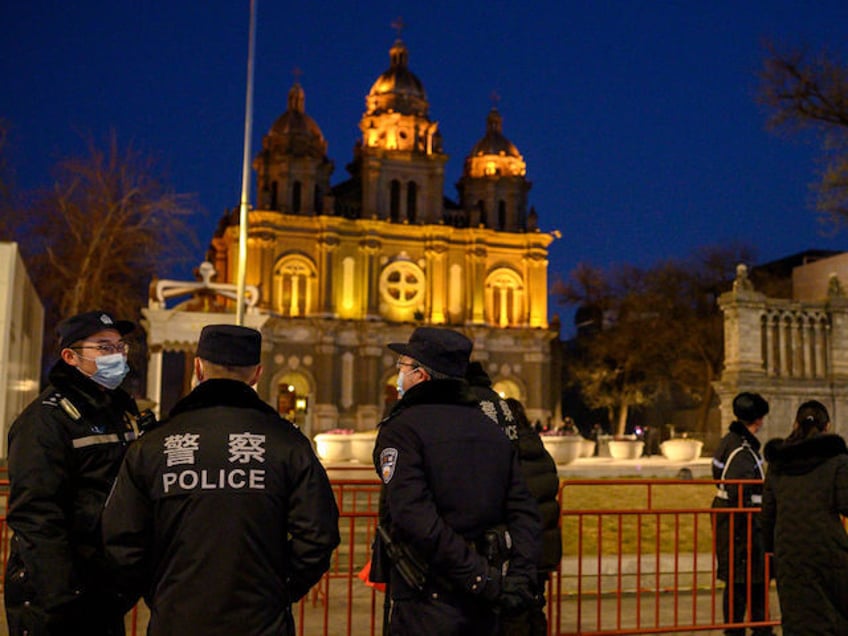 Policemen stand in front of St. Joseph's Church during a mass on Christmas eve in Beijing on December 24, 2020. (Photo by NOEL CELIS / AFP) (Photo by NOEL CELIS/AFP via Getty Images)