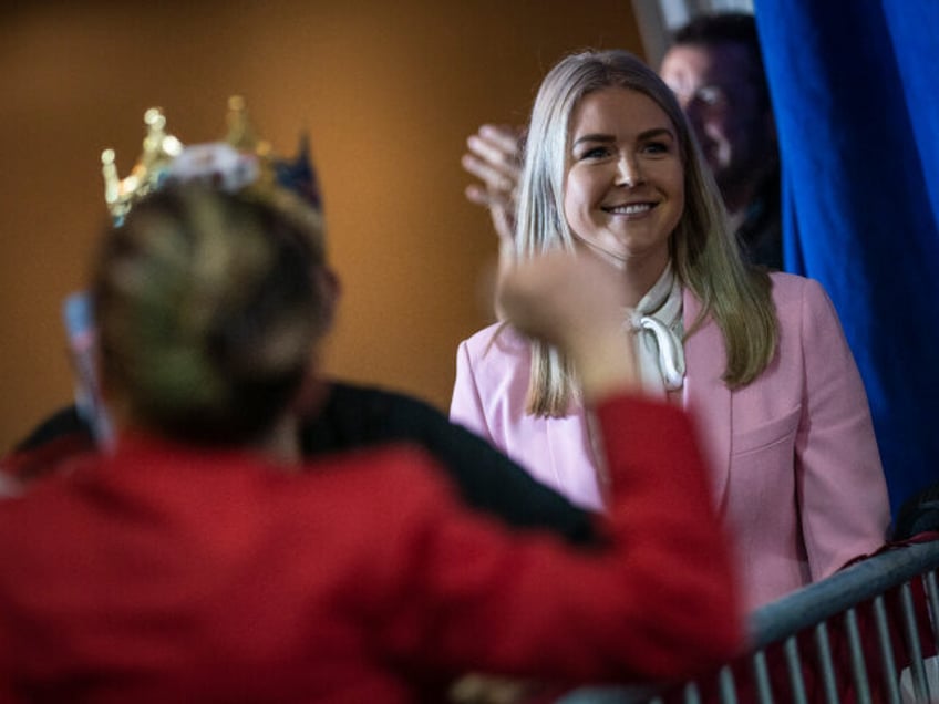 Manchester, NH - April 27 : Karoline Leavitt listens as former President Donald Trump spea