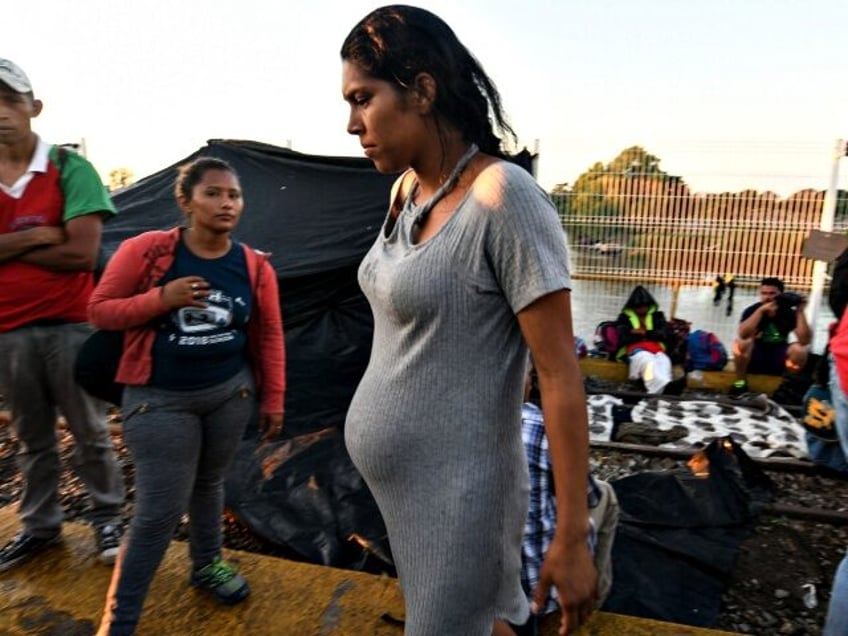 A Honduran pregnant woman taking part in a caravan heading to the US, waits to cross the b