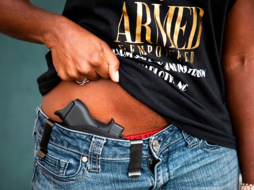 Kisha Kincaid shows her gun for the camera at a gun range in Concord, North Carolina, on A