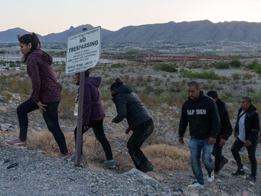 Migrants are apprehended by United States Border Patrol agents (not shown in this crop) wh