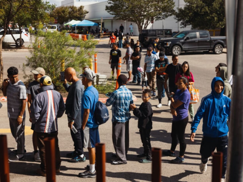 Groups of migrants wait outside the Migrant Resource Center to receive food from the San A